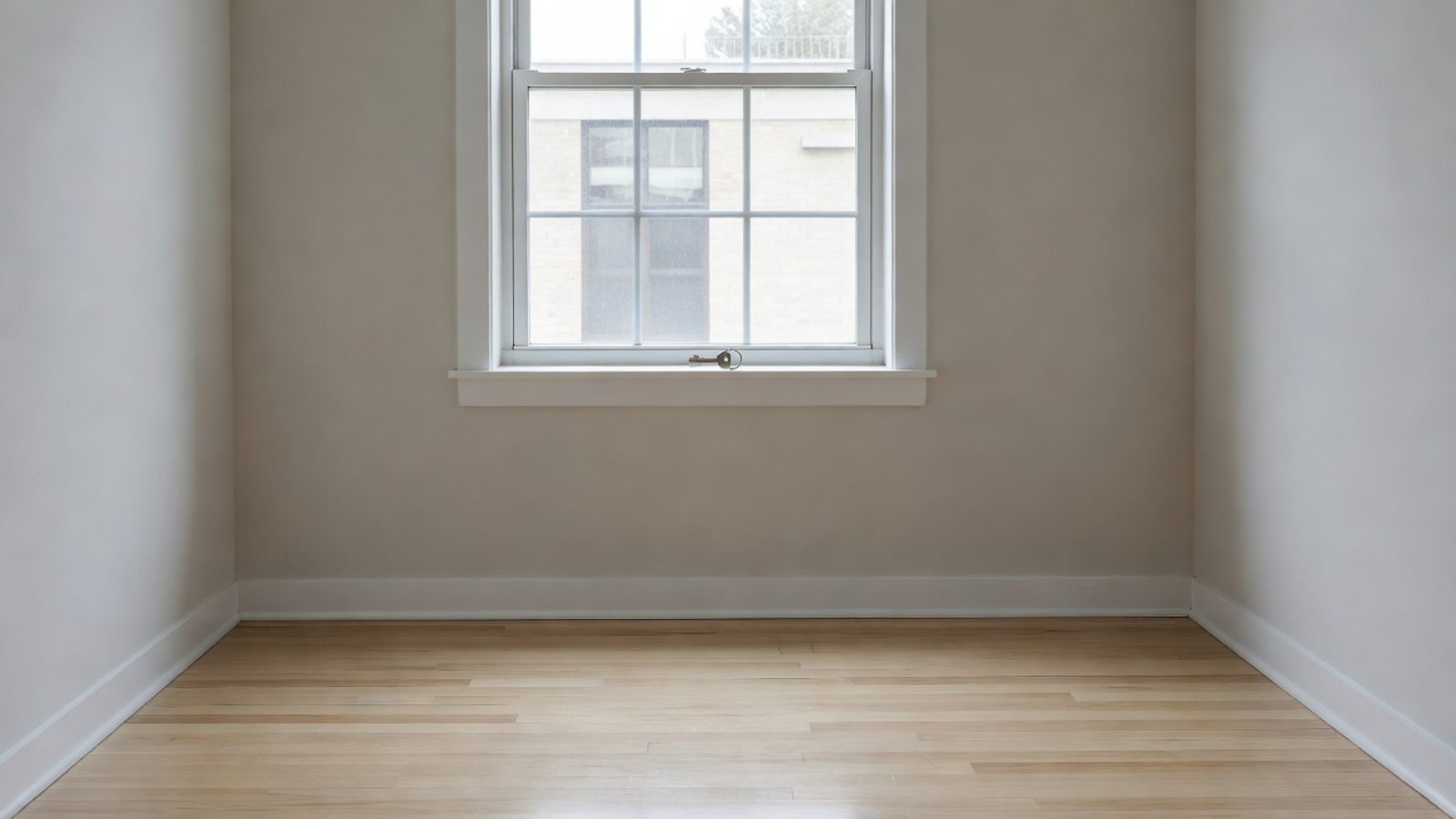 Empty rental bedroom with a house key on the windowsill